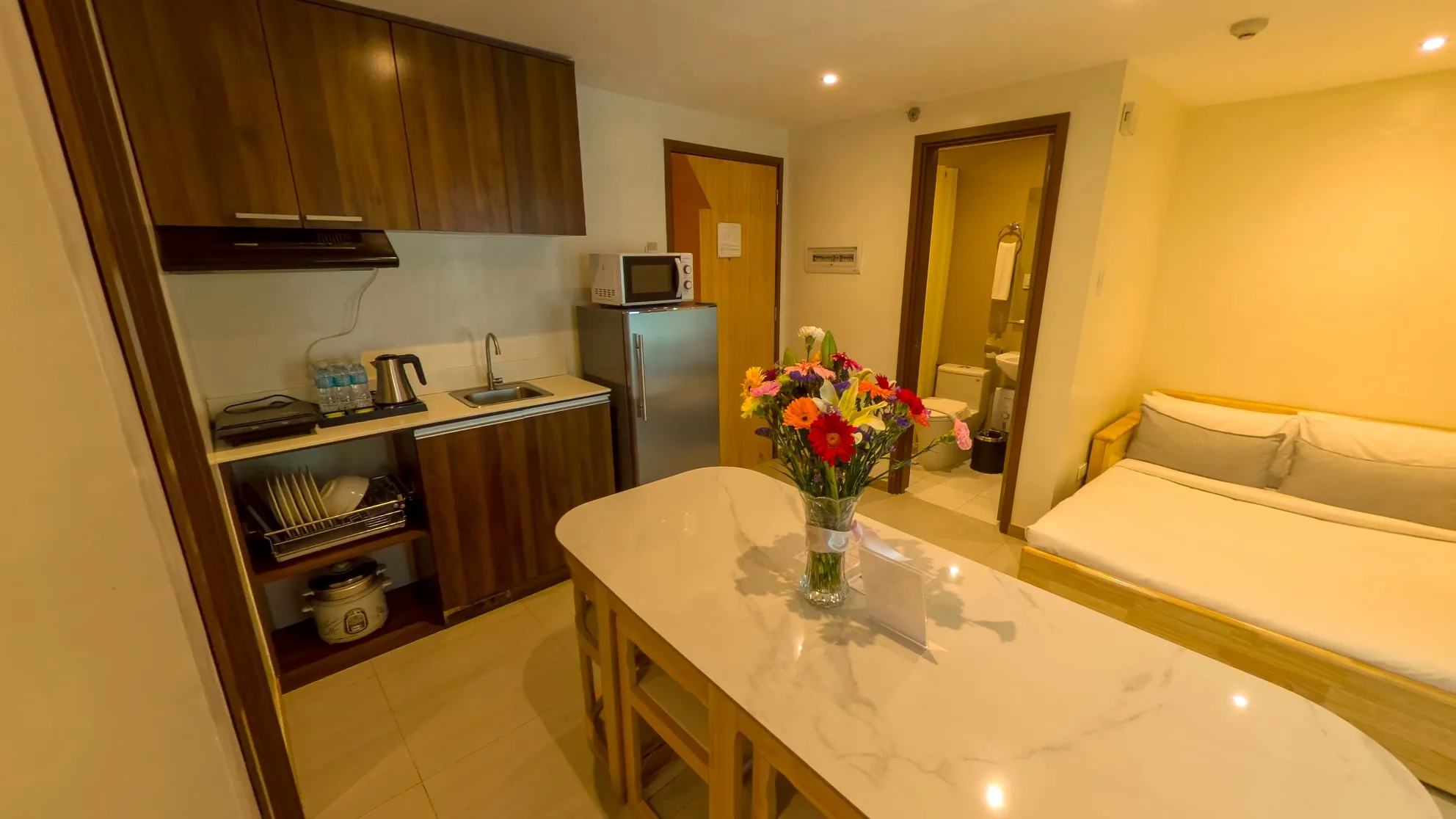 Two Bedroom Standard Room kitchenette and dining table with fresh flowers